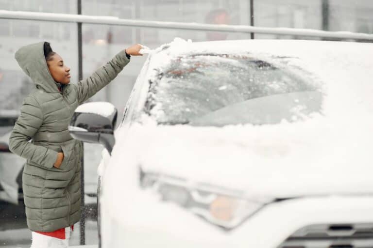 femme retirant neige du toit de sa voiture